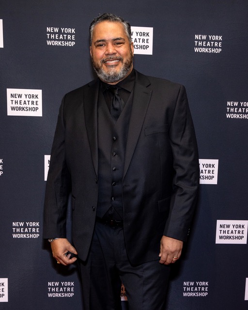 Freedome at the New York Theatre Workshop gala, full-length in a dark three-piece suit