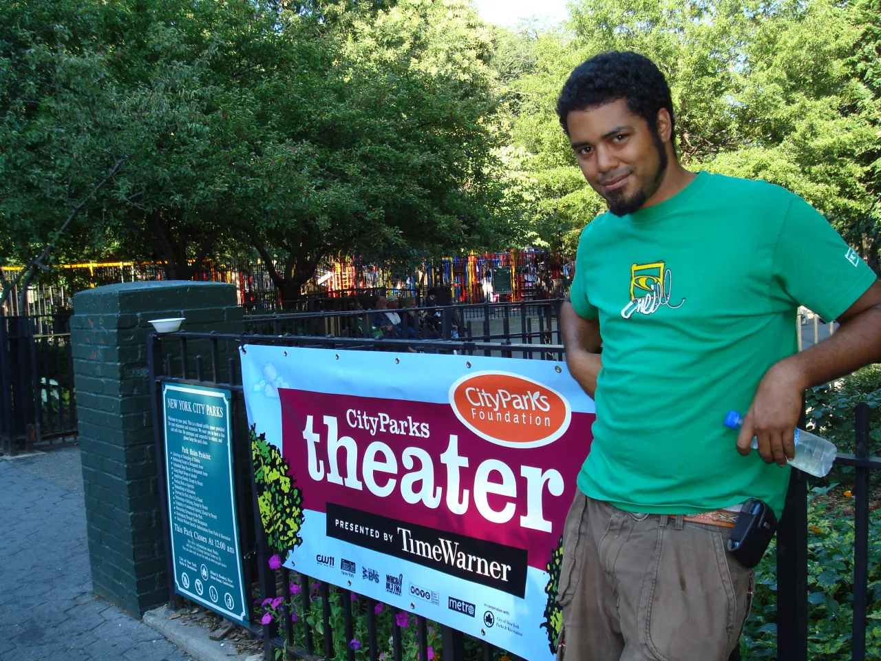 Freedome Bradley-Ballentine beside a CityParks theater sign in a park