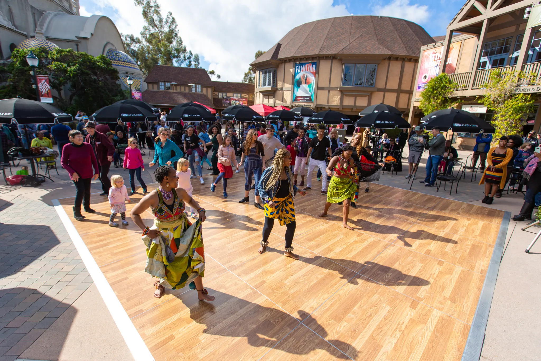 Residents dancing together on the Old Globe plaza